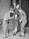 Lone Pine, California. Soldiers assist elderly evacuee of Japanese descent leave car steps in transfer to War Relocation Authority center at Manzanar. Photo: Department of the Interior. War Relocation Authority. Source: National Archives.