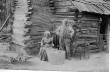 Former Slaves Standing in Front of their Cabin