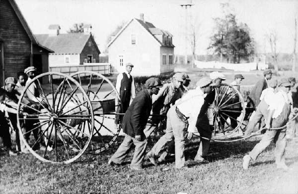 Postcard of Young Men Pushing and Pulling Carts in a Yard at the Howard Orphanage and Industrial School